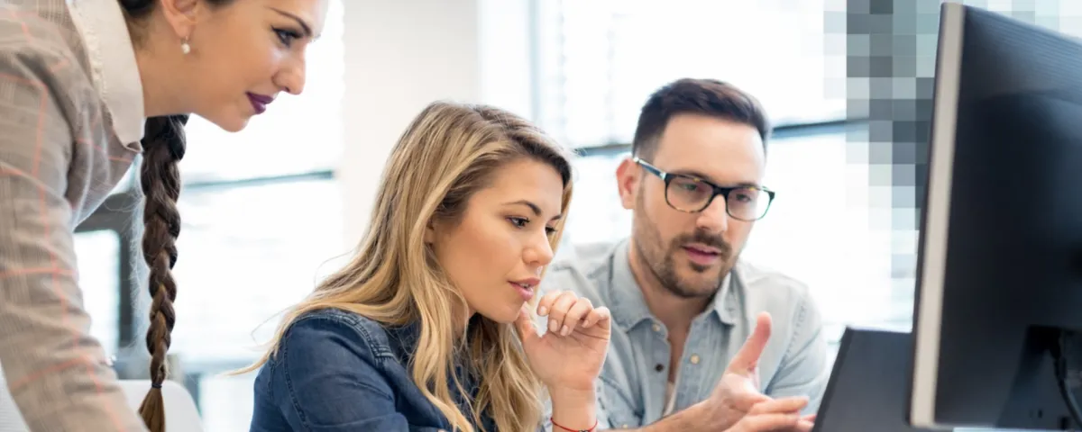 Kollegen vor Laptop-Screen arbeiten gemeinsam