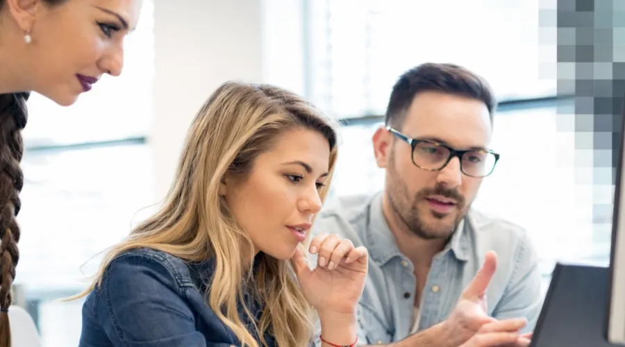 Kollegen vor Laptop-Screen arbeiten gemeinsam